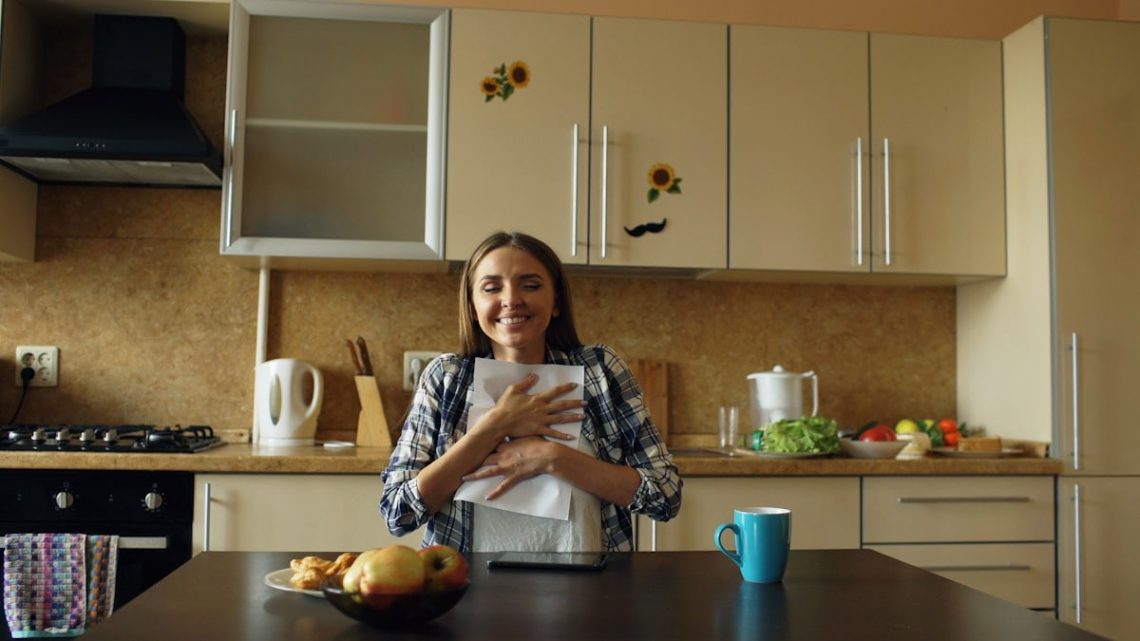 Attractive happy woman recieve good news reading letter in the kitchen while have breakfast at home
