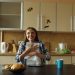 Attractive happy woman recieve good news reading letter in the kitchen while have breakfast at home
